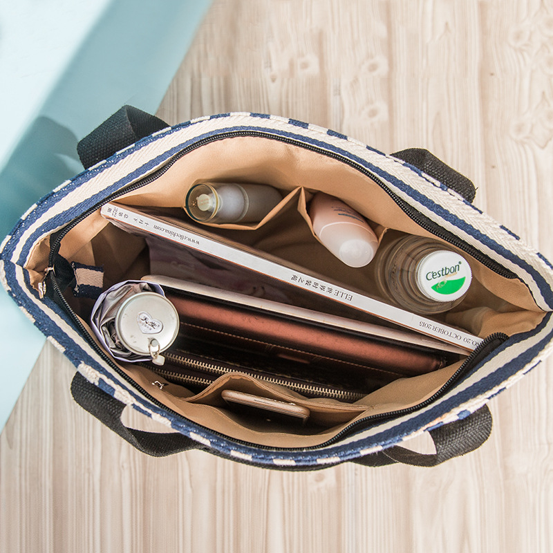 Prugasta platnena tote torba sa zatvaračem, dvostruke naramenice, unutarnji džep sa zatvaračem i prostor za telefon i osobnu iskaznicu