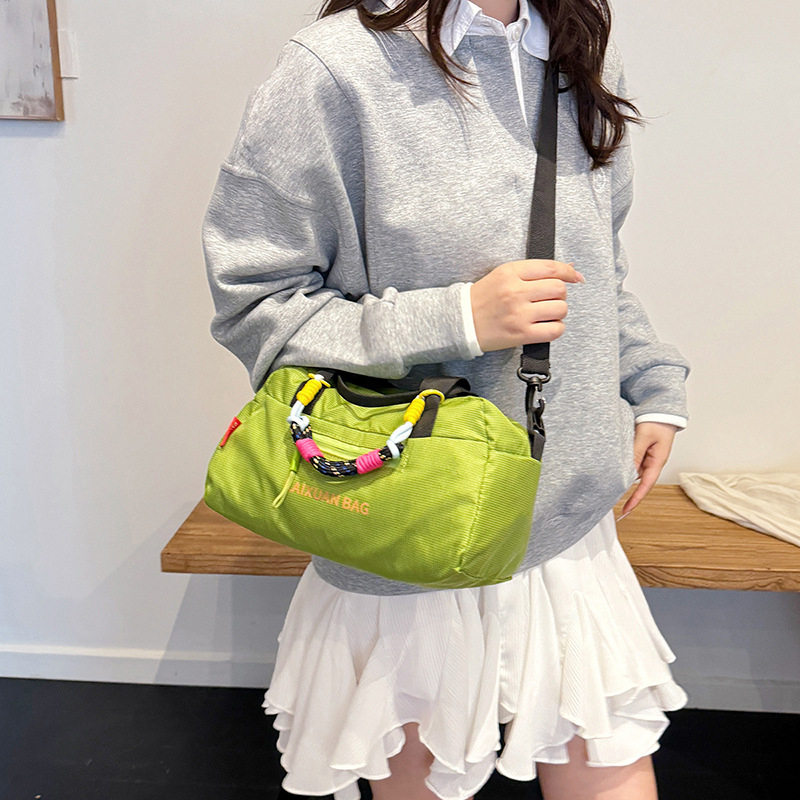 Ženska crossbody torba od vodootporne tkanine, gradski minimalistički stil, vertikalno kvadratnog oblika, zatvarač, laminirani unutarnji džep, tri naramenice.