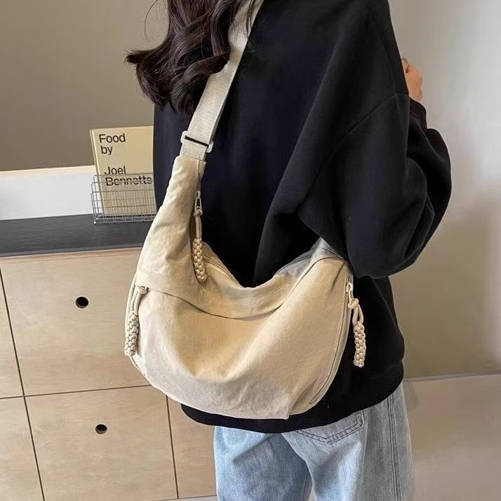 Crossbody torba u stilu dumpling bun, vanjski dio od najlona s podlogom od poliestera, unisex dizajn, proljeće 2025 lansiranje, za svakodnevnu uporabu.