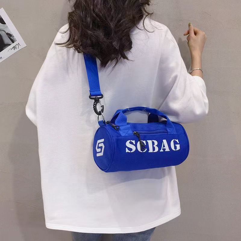 Geantă crossbody, stil japonez, nylon, design cilindric bucket, închidere cu fermoar, buzunar cu fermoar în interior și buzunar pentru telefon.