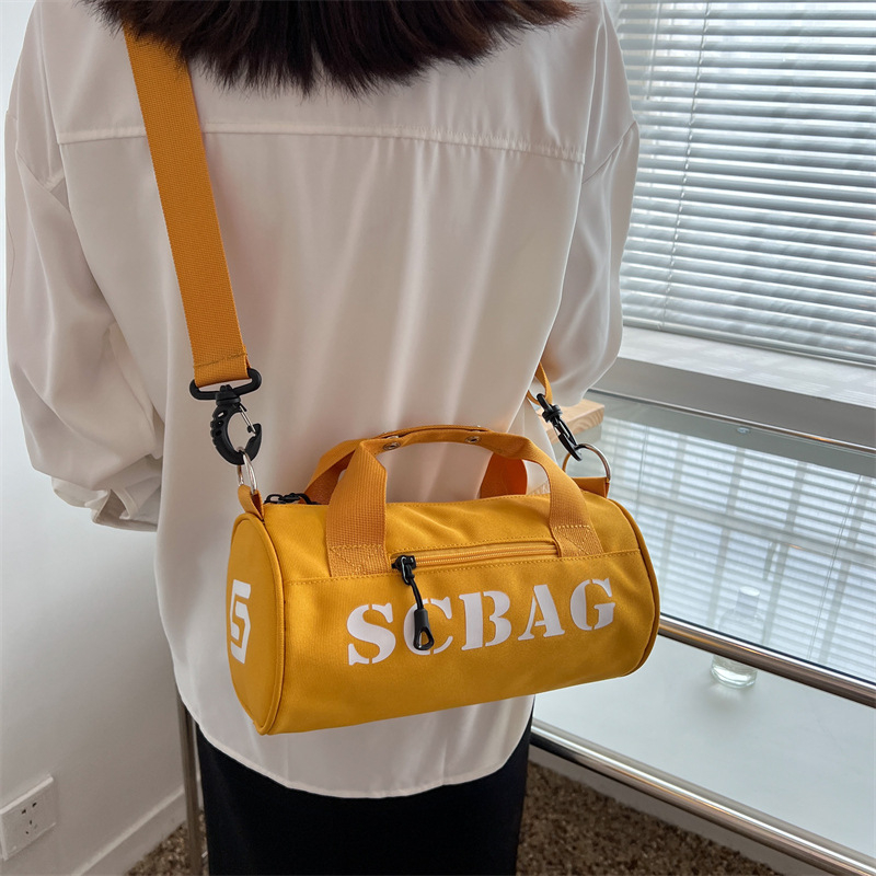 Geantă crossbody, stil japonez, nylon, design cilindric bucket, închidere cu fermoar, buzunar cu fermoar în interior și buzunar pentru telefon.