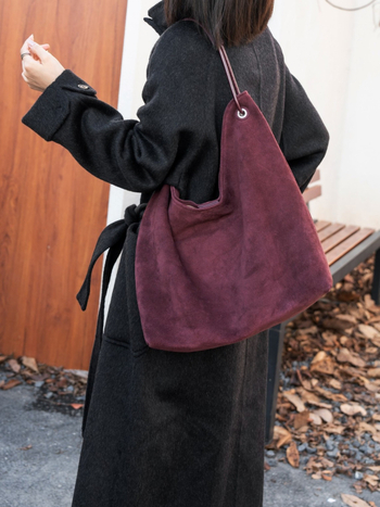 Nubukinės odos kibiro formos delninė pečių su minkšta rankena, matinė apdaila, poliesterio-paminkštintas pamušalas, vidinės kišenės telefonui ir dokumentams, ruduo 2025