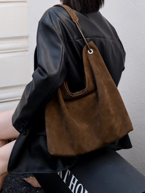 Nubukinės odos kibiro formos delninė pečių su minkšta rankena, matinė apdaila, poliesterio-paminkštintas pamušalas, vidinės kišenės telefonui ir dokumentams, ruduo 2025