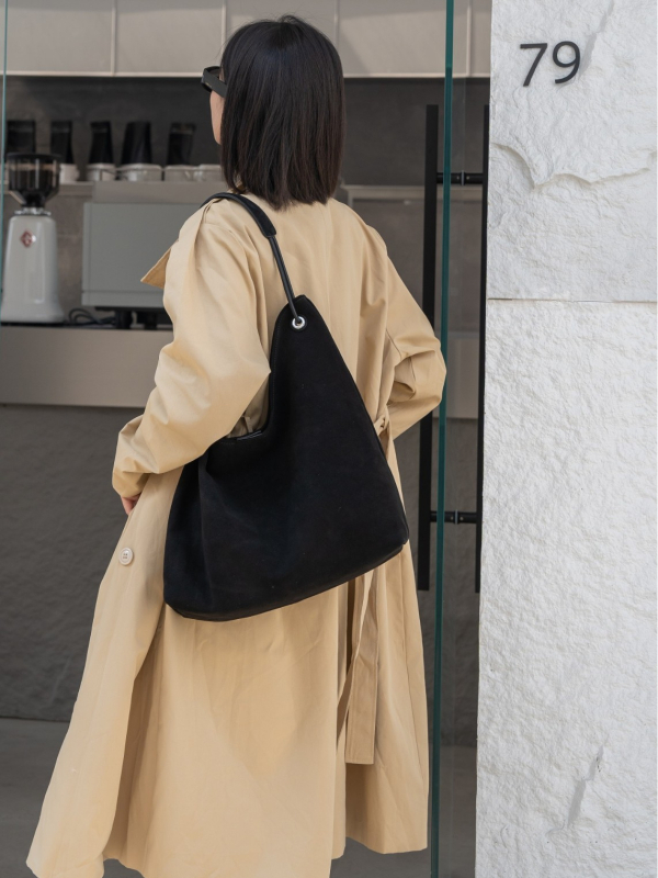 Nubukinės odos kibiro formos delninė pečių su minkšta rankena, matinė apdaila, poliesterio-paminkštintas pamušalas, vidinės kišenės telefonui ir dokumentams, ruduo 2025