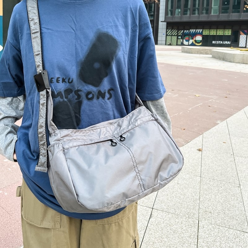 Keresztpántos bucket táska cipzárral, Oxford anyagból, poliészter béléssel, egy vállpánttal és belső zsejtekkel