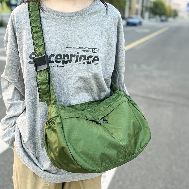 Keresztpántos bucket táska cipzárral, Oxford anyagból, poliészter béléssel, egy vállpánttal és belső zsejtekkel