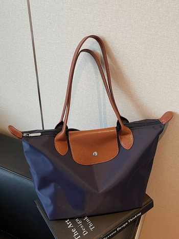 Torba tote u obliku dumplinga s preklopnim zatvaranjem, Oxford platno, podstava od poliestera, unutarnji džep na zip, jedna naramenica, jesen 2025 izdanje