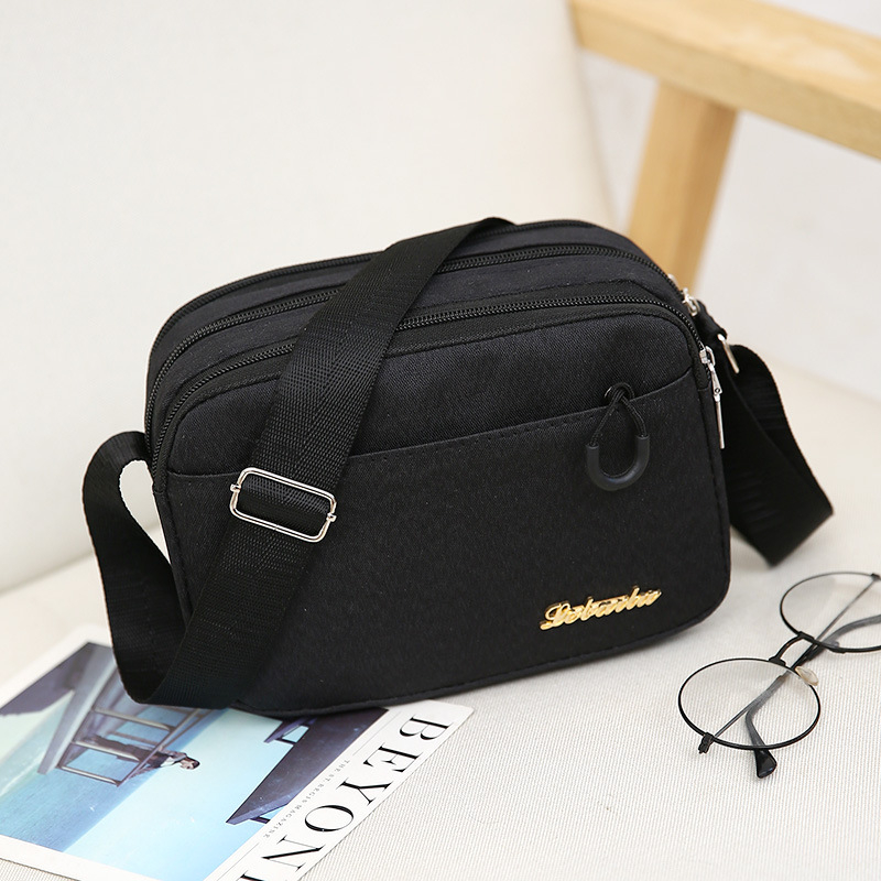 Ženska crossbody torba, kvadratnog oblika, Oxford plat, zatvarač, poliester podstava, jedna naramenica, urbani minimalistički stil