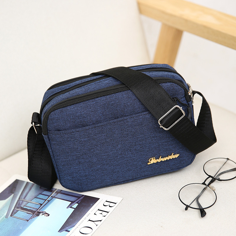 Ženska crossbody torba, kvadratnog oblika, Oxford plat, zatvarač, poliester podstava, jedna naramenica, urbani minimalistički stil