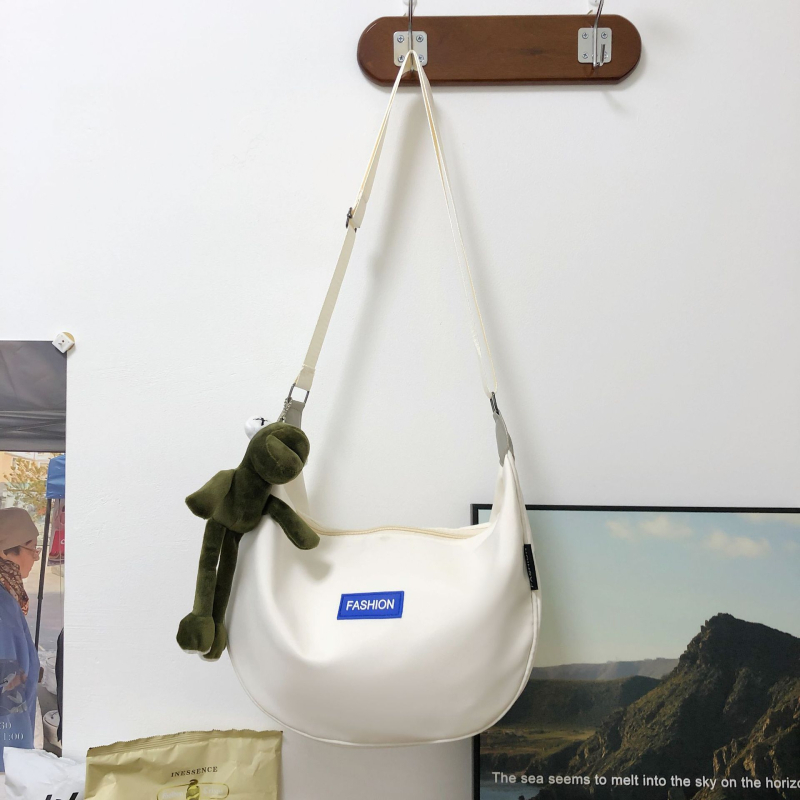 Crossbody Dumpling torba od Oxford platna — mekana konstrukcija, oblik dumplinga, zatvaranje poklopca, unutarnja džep s ID karticom i džep sa zipom