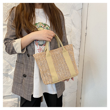 Szalmából készült bucket-stílusú tote táska egy vállpánttal és mágneszárral