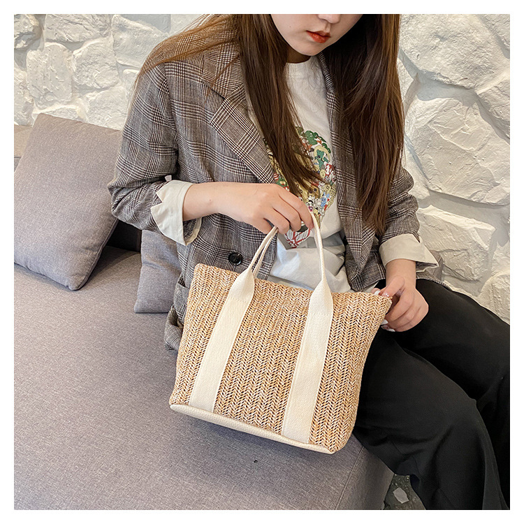 Szalmából készült bucket-stílusú tote táska egy vállpánttal és mágneszárral