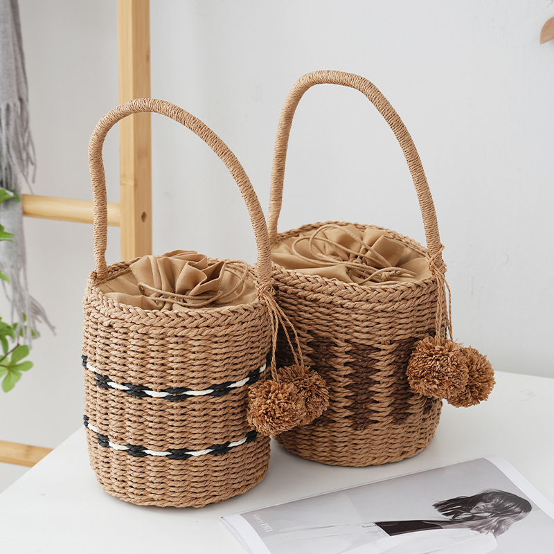 Ženska bucket bag od papirnatog užeta, podstava od platna, zatvaranje šnnom, vodoravni pravokutni oblik, unutarnji džep za dokumente