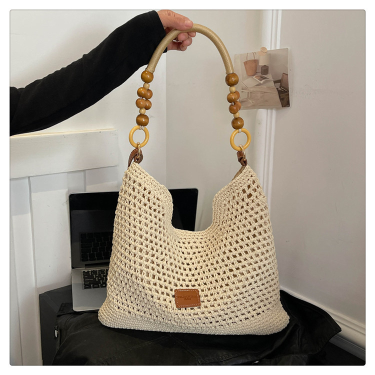 Kötött, henger alakú válltáska cipzárral; belső cipzáras zseb; egy vállpánt