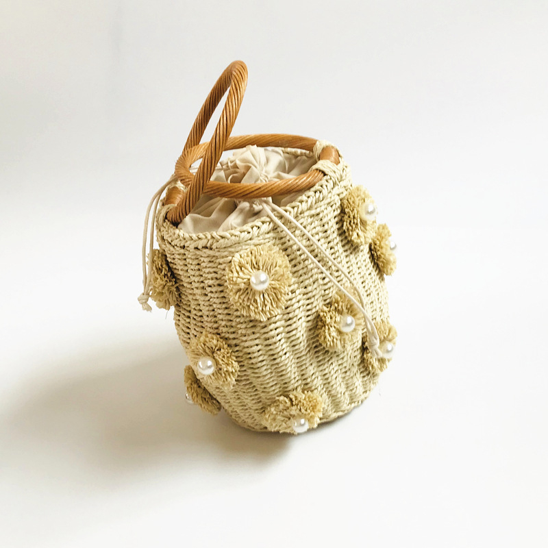 Szalmából készült vödrös táska virágmintával, puha hengeres forma, szalagnyitású