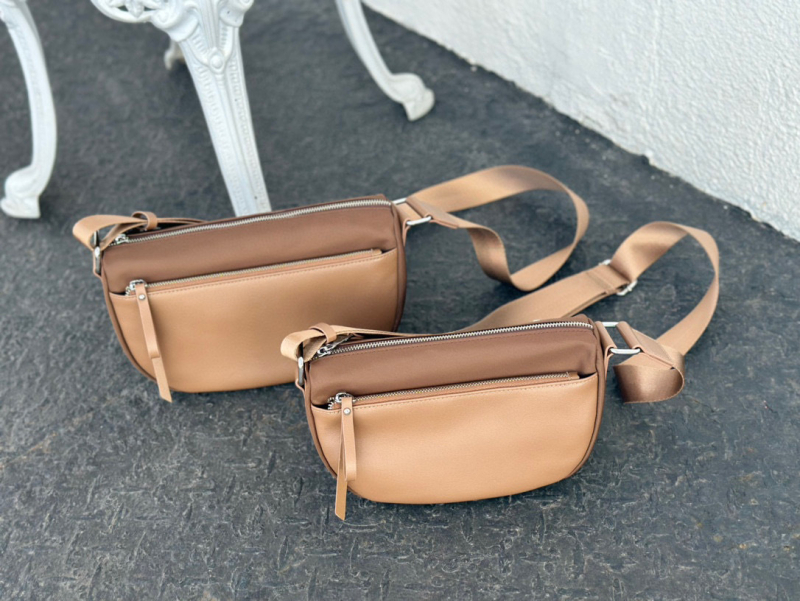 Valódi bőrből készült crossbody táska vízálló anyaggal, horizontális négyzet alakú forma, cipzáros zárás, belső zsebek telefonra és személyi igazolványra — utcai divat stílus