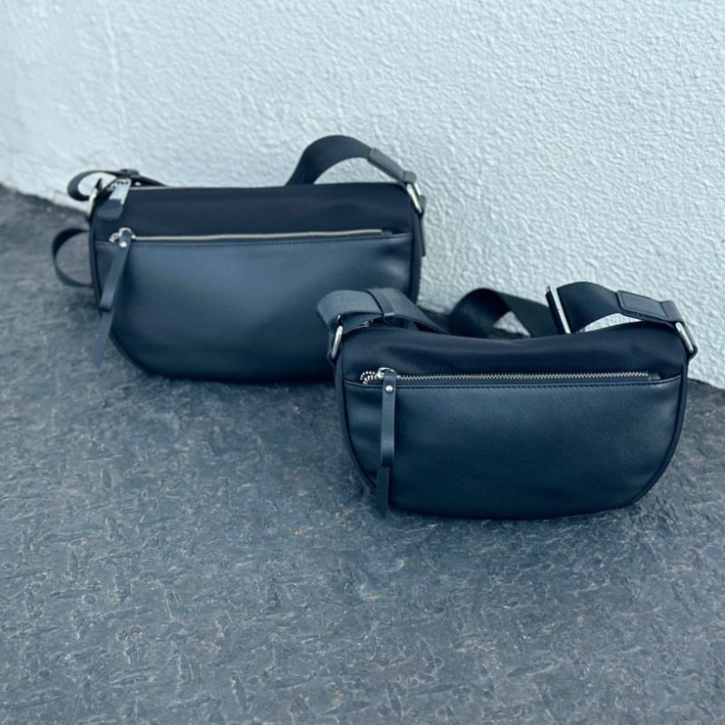 Valódi bőrből készült crossbody táska vízálló anyaggal, horizontális négyzet alakú forma, cipzáros zárás, belső zsebek telefonra és személyi igazolványra — utcai divat stílus