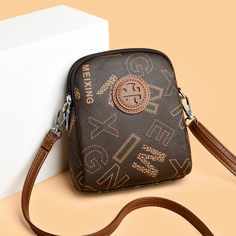 PVC crossbody torbica, uspravnog kvadrantnog oblika, zatvarač, pretinci za telefon i dokumente