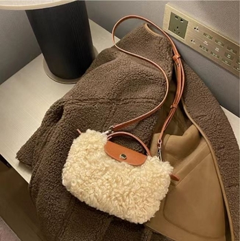Vunena crossbody torbica s puhastom teksturom, u vodoravnom kvadratnom obliku, magnetno zatvaranje i podstava od poliestera.