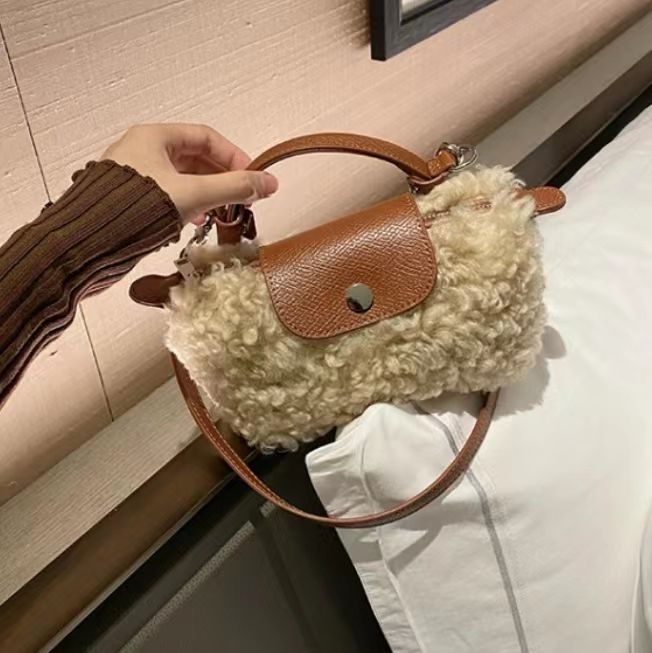 Vunena crossbody torbica s puhastom teksturom, u vodoravnom kvadratnom obliku, magnetno zatvaranje i podstava od poliestera.