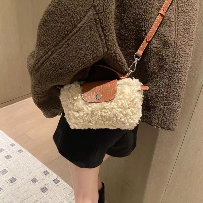 Vunena crossbody torbica s puhastom teksturom, u vodoravnom kvadratnom obliku, magnetno zatvaranje i podstava od poliestera.