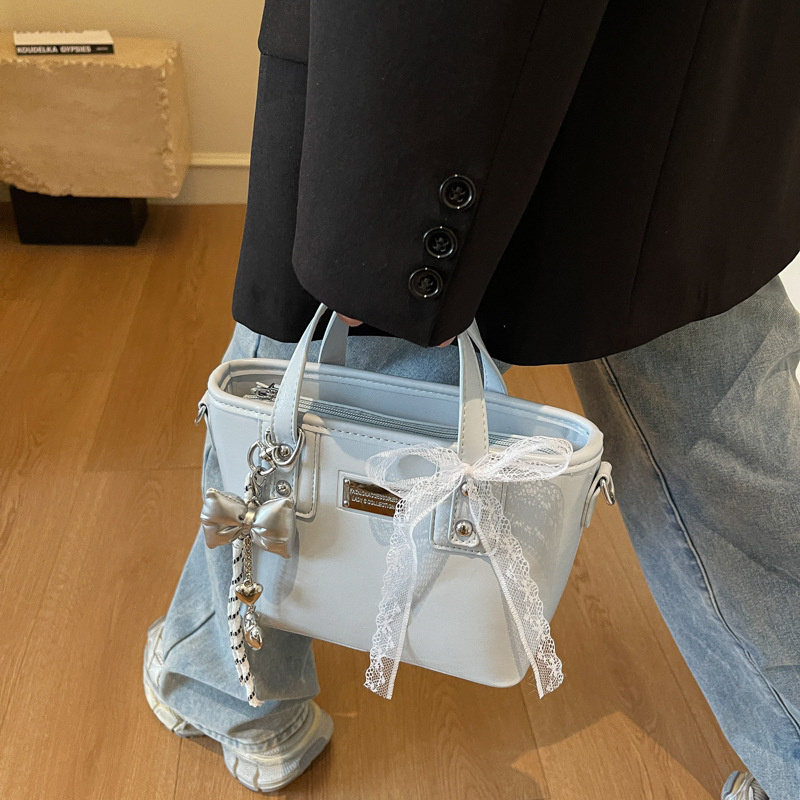 Ženska PU crossbody torbica, srednje veličine, oblik kante, zatvarač, poliester podstava, gradski minimalistički stil, svakodnevna upotreba, proljeće 2026