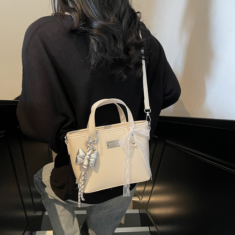 Ženska PU crossbody torbica, srednje veličine, oblik kante, zatvarač, poliester podstava, gradski minimalistički stil, svakodnevna upotreba, proljeće 2026