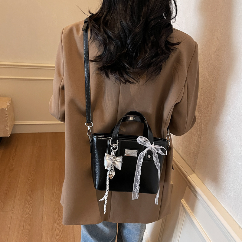 Ženska PU crossbody torbica, srednje veličine, oblik kante, zatvarač, poliester podstava, gradski minimalistički stil, svakodnevna upotreba, proljeće 2026