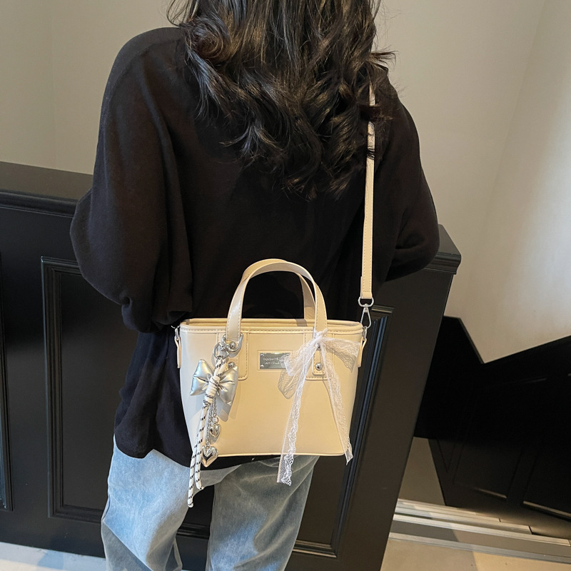 Ženska PU crossbody torbica, srednje veličine, oblik kante, zatvarač, poliester podstava, gradski minimalistički stil, svakodnevna upotreba, proljeće 2026