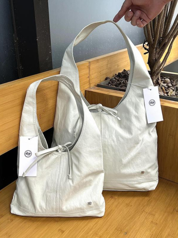Sweetheart PU tote torba s bucket siluetom, zatvaranje vrpcom, poliester podstava, unutarnji džep za telefon i jedna naramenica za svakodnevnu uporabu.