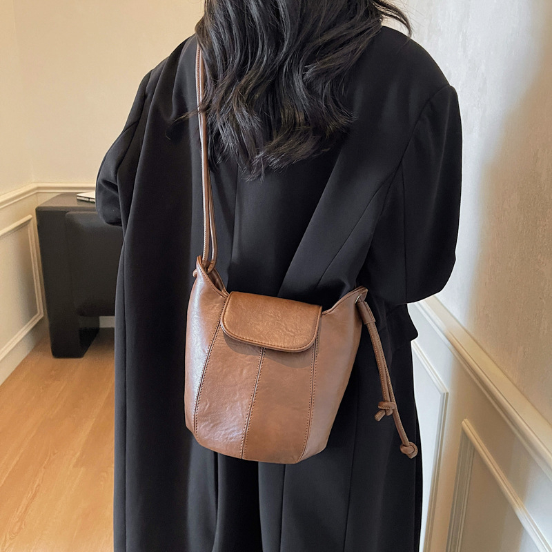 Τσάντα Bucket με αστικό μινιμαλισμό, PU υλικό, διαρύθμιση crossbody με ιμάντα ώμου, άνοιγμα με κάλυμμα, εσωτερική θήκη με φερμουάρ, πολυεστερική επένδυση, κυκλοφορία φθινοπω 2025