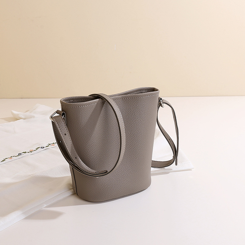 PU anyagú vödrös táska mágneszáras záródással, belső zipzáros rekesz és telefonrekesz, poliészter bélés, városi minimalista stílus