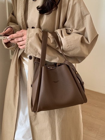 Enzun geantă bucket din piele ecologică — stil retro, lansare toamnă 2025. Formă de găleată, închidere magnetică. Interior: buzunar cu fermoar, buzunar pentru telefon, buzunar pentru documente, buzunar pentru aparat foto. Căptușeală PU. Cu capac. Curea de 