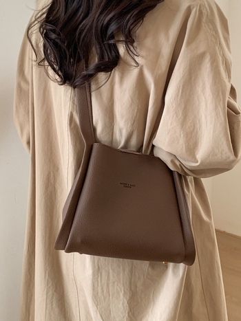 Enzun geantă bucket din piele ecologică — stil retro, lansare toamnă 2025. Formă de găleată, închidere magnetică. Interior: buzunar cu fermoar, buzunar pentru telefon, buzunar pentru documente, buzunar pentru aparat foto. Căptușeală PU. Cu capac. Curea de 