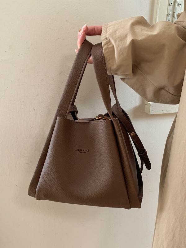 Enzun geantă bucket din piele ecologică — stil retro, lansare toamnă 2025. Formă de găleată, închidere magnetică. Interior: buzunar cu fermoar, buzunar pentru telefon, buzunar pentru documente, buzunar pentru aparat foto. Căptușeală PU. Cu capac. Curea de 