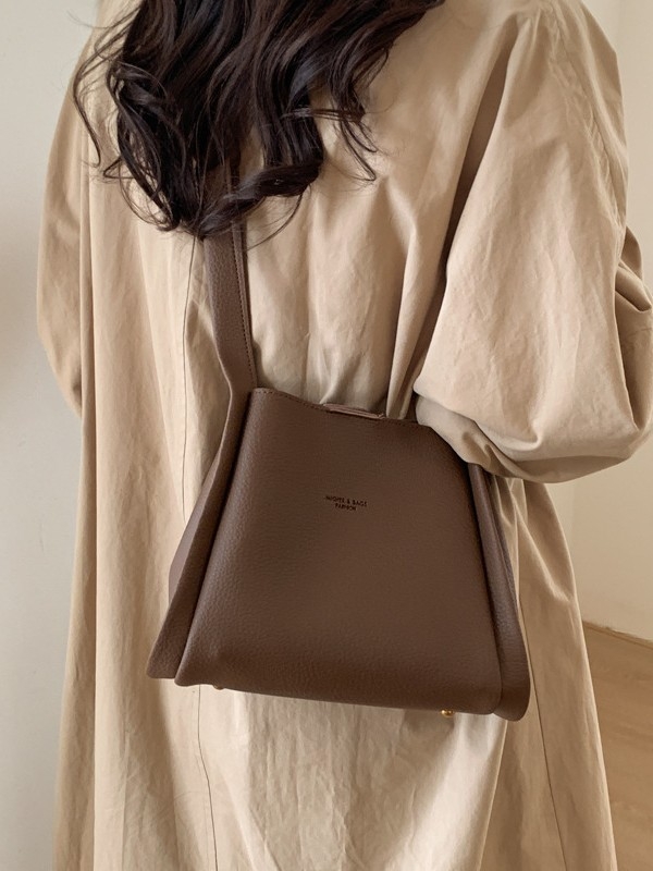 Enzun geantă bucket din piele ecologică — stil retro, lansare toamnă 2025. Formă de găleată, închidere magnetică. Interior: buzunar cu fermoar, buzunar pentru telefon, buzunar pentru documente, buzunar pentru aparat foto. Căptușeală PU. Cu capac. Curea de 