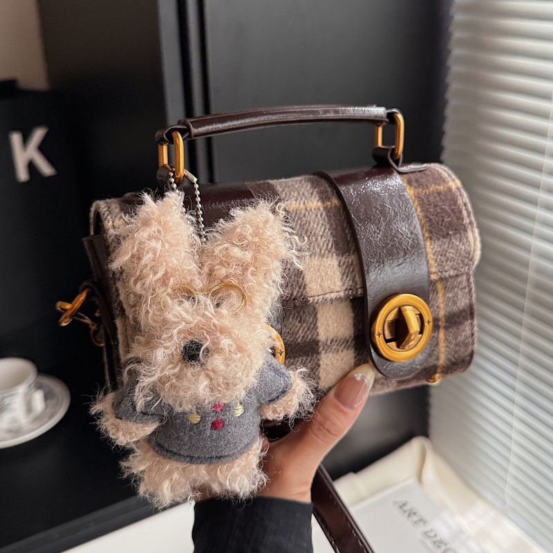 Vunena torbica u gradskom minimalističkom stilu, vodoravni kvadratni oblik, zatvaranje brava, podstava od sintetičke kože