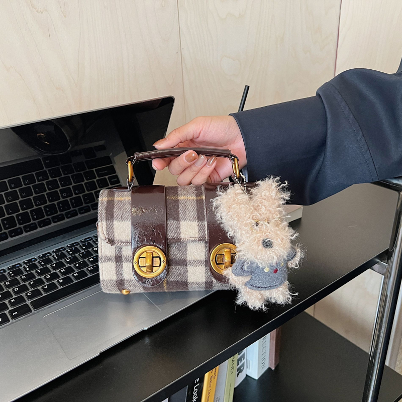 Vunena torbica u gradskom minimalističkom stilu, vodoravni kvadratni oblik, zatvaranje brava, podstava od sintetičke kože