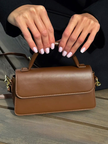 PU crossbody torba, horizontálnog kvadratnog oblika, unutarnji džepovi za telefon i dokumente, magnetsko zatvaranje, urbani minimalistički stil.