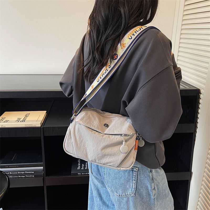 Ženska crossbody torba – lagana i kompaktna, vodoravnog kvadratnog oblika, zatvarač, poliester podstava, jedna naramenica, svakodnevna uporaba, jesen 2025, stil zrele žene