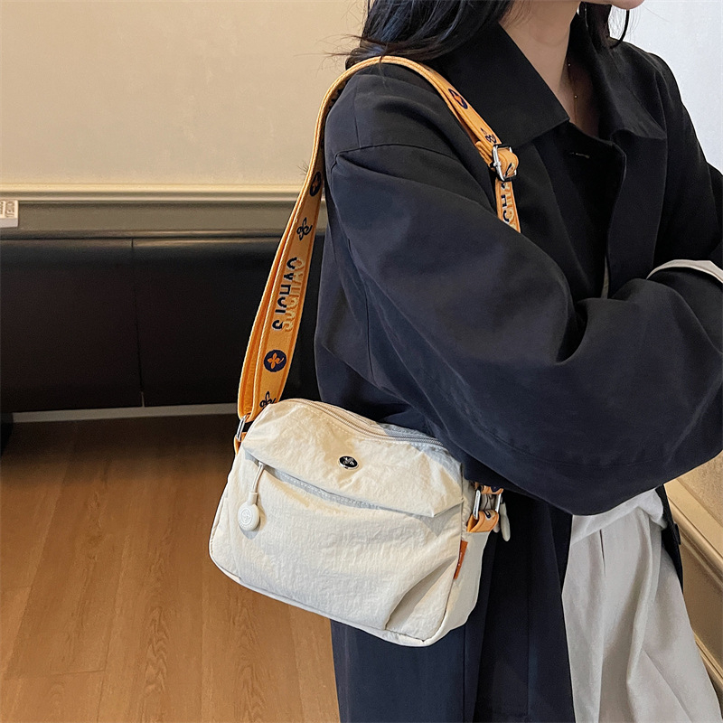 Ženska crossbody torba – lagana i kompaktna, vodoravnog kvadratnog oblika, zatvarač, poliester podstava, jedna naramenica, svakodnevna uporaba, jesen 2025, stil zrele žene
