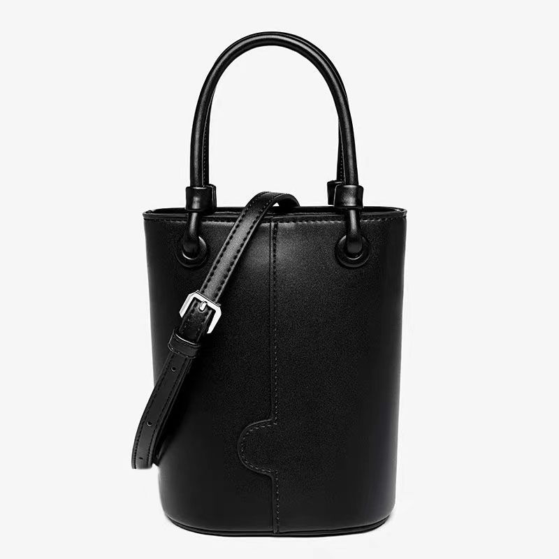 Crvena bucket torba s remenom za nošenje preko tijela i ručnim držalom, elegantna i svestrana