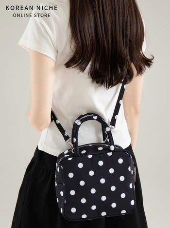 Punktēta kvadrātveida soma (Materiāls: neilons; Pārveide: horizontāla kvadrāta; Aizvērums: rāvējslēdzējs; Iekšpuse: poliestera pamatne; Iekšējais kabats ar rāvējslēdzēju un ID kabata; Plecu siksna: viena)