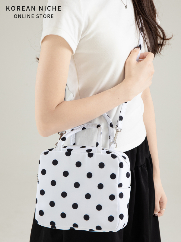 Punktēta kvadrātveida soma (Materiāls: neilons; Pārveide: horizontāla kvadrāta; Aizvērums: rāvējslēdzējs; Iekšpuse: poliestera pamatne; Iekšējais kabats ar rāvējslēdzēju un ID kabata; Plecu siksna: viena)