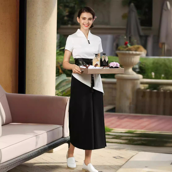 Uniformă pentru salon de înfrumusețare: costum cu pantaloni croiți în talie largă, decolteu în V, mâneci scurte; material din amestec de bumbac (50–70% bumbac, 15% Cupro); țesătură: bumbac; mâneci: scurte; decolteu: V.