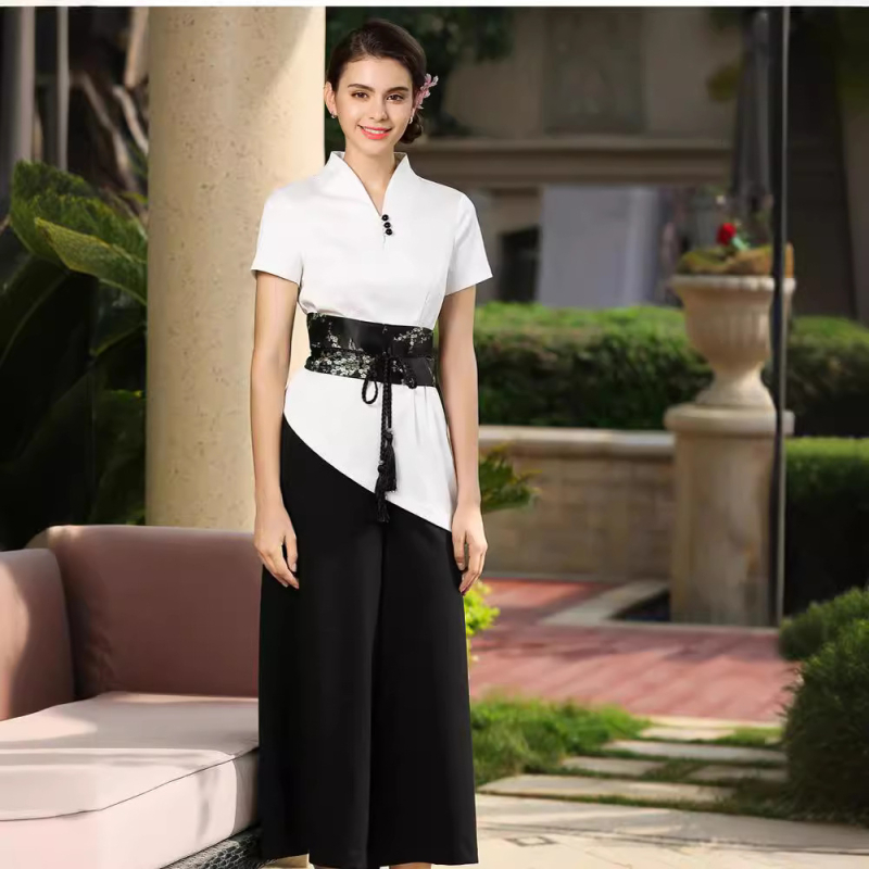 Uniformă pentru salon de înfrumusețare: costum cu pantaloni croiți în talie largă, decolteu în V, mâneci scurte; material din amestec de bumbac (50–70% bumbac, 15% Cupro); țesătură: bumbac; mâneci: scurte; decolteu: V.