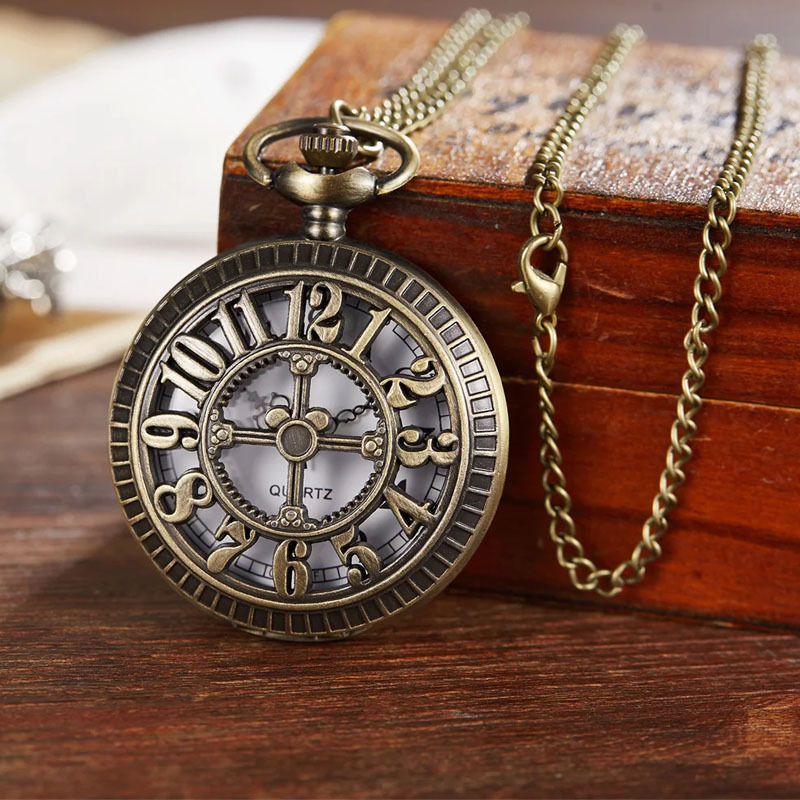 Bronzas caurspīdīgs dizains kvarca kabatas pulkstenim ar kulonu uz džemperi ar arābu cipariem (pasaules laiks; korpuss no sakaļas; apaļš cipferis; spirālkorona)