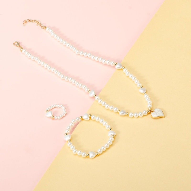 Vaikų perlinių papuošalų rinkinys su širdies formos pakabuku: karoliai, apyrankė ir žiedas (Medžiaga: plastikas/rišalas; Grandinė: perlų eilė; Pakabuko medžiaga: lydinys; Rankų darbo; Amžiaus diapazonas: 3–6, 6–10 ir vyresni nei 10 metų)