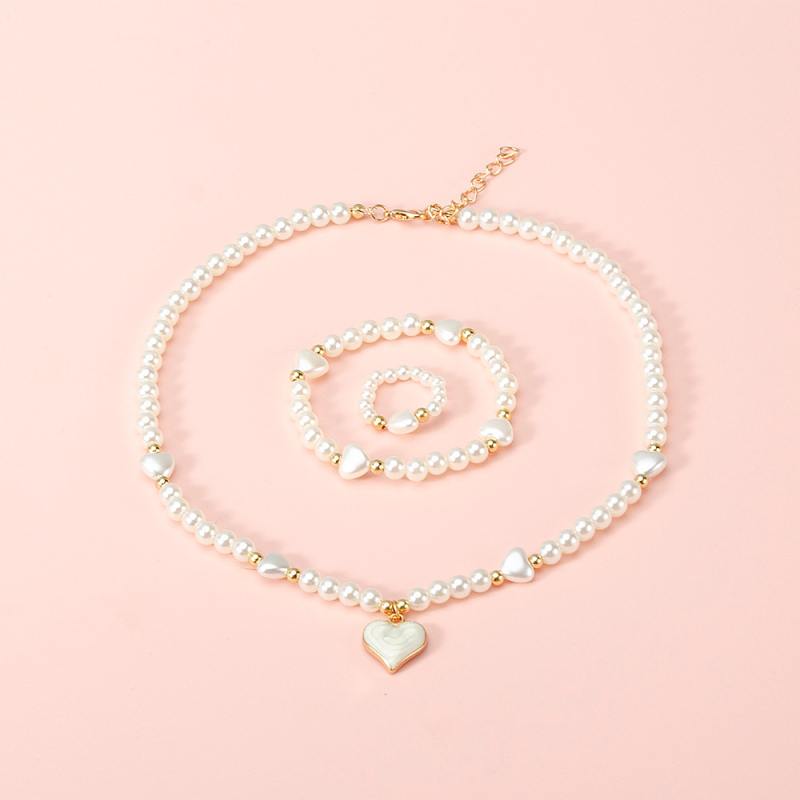 Vaikų perlinių papuošalų rinkinys su širdies formos pakabuku: karoliai, apyrankė ir žiedas (Medžiaga: plastikas/rišalas; Grandinė: perlų eilė; Pakabuko medžiaga: lydinys; Rankų darbo; Amžiaus diapazonas: 3–6, 6–10 ir vyresni nei 10 metų)