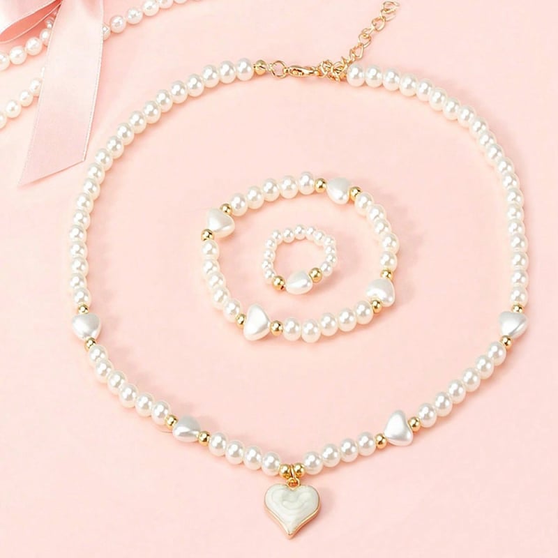 Vaikų perlinių papuošalų rinkinys su širdies formos pakabuku: karoliai, apyrankė ir žiedas (Medžiaga: plastikas/rišalas; Grandinė: perlų eilė; Pakabuko medžiaga: lydinys; Rankų darbo; Amžiaus diapazonas: 3–6, 6–10 ir vyresni nei 10 metų)